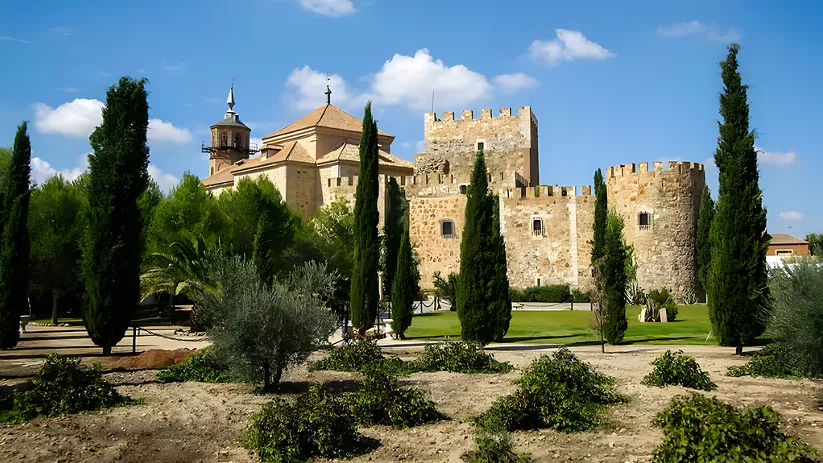 Iglesia de piedra al final de una calle arbolada