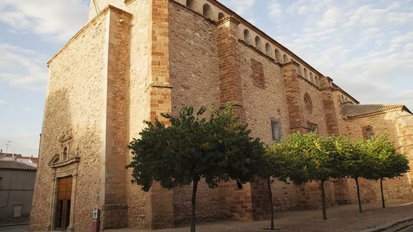 Vista lateral de la iglesia de Santiago el Mayor en Membrilla (Ciudad Real), edificio de piedra y estilo tradicional manchego.