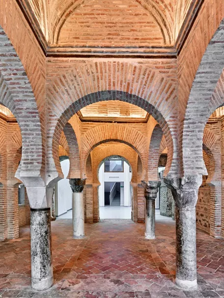 Sala con arcos de ladrillo y columnas de piedra