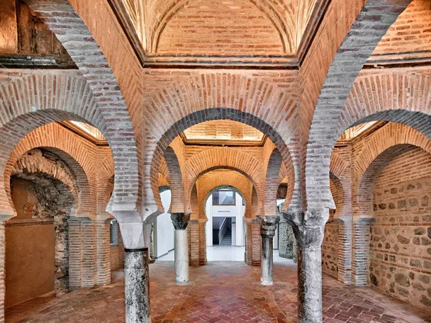 Sala con arcos de ladrillo y columnas de piedra