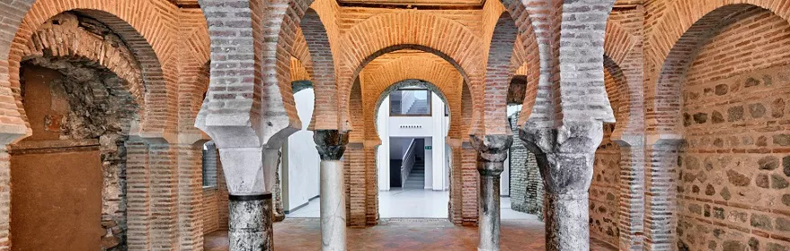Sala con arcos de ladrillo y columnas de piedra