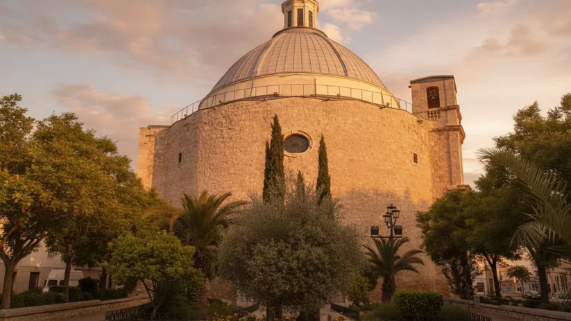 Iglesia de piedra con gran cúpula entre jardines