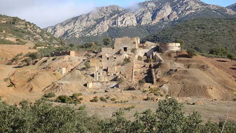 Conjunto de ruinas industriales en ladera rodeada de sierras