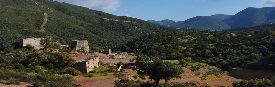 Paisaje montañoso con antiguas construcciones mineras entre vegetación