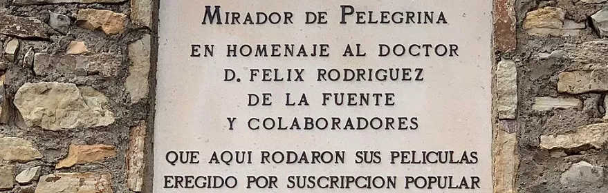 Placa conmemorativa en muro de piedra con arco inferior.