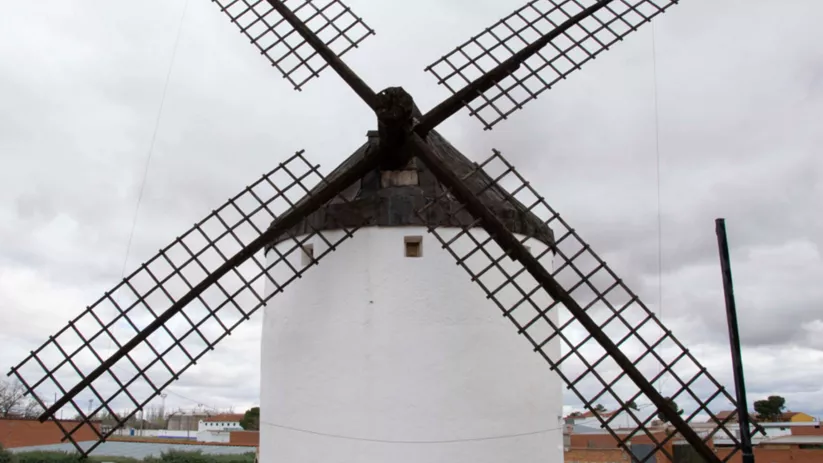Molino de viento tradicional en lo alto de un cerro.