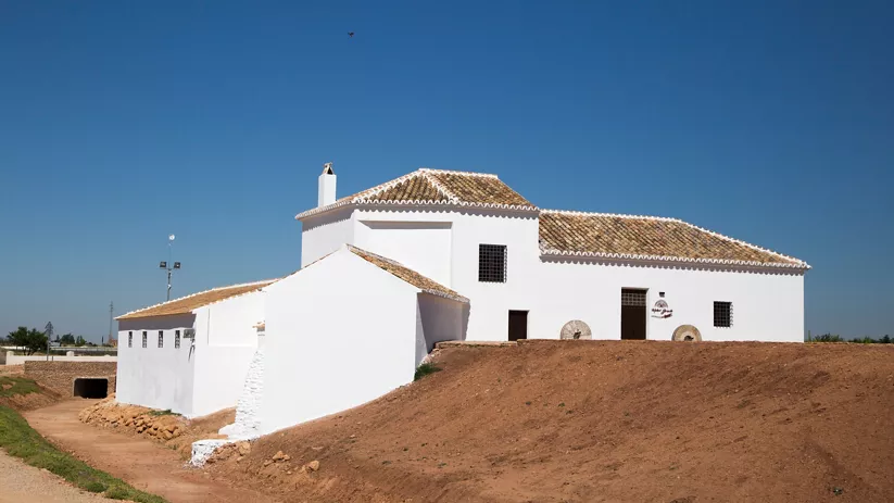 Edificio tradicional encalado con cubierta de teja bajo cielo despejado