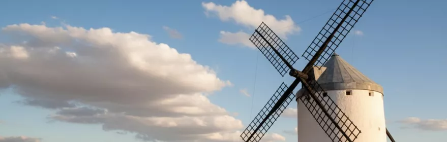Molino sobre llanura abierta con campos secos y horizonte lejano.