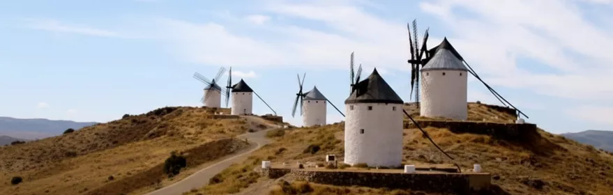 Conjunto de molinos tradicionales en loma seca bajo cielo nublado.