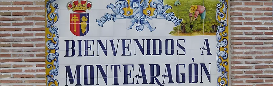 Panel cerámico de bienvenida con letras azules y escudo decorativo