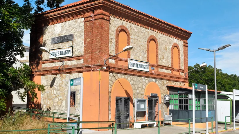 Antigua estación de tren de ladrillo y piedra junto al andén