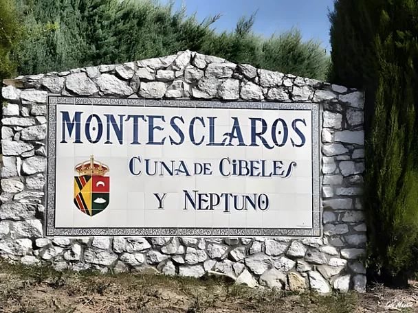 Panel cerámico de bienvenida sobre muro de piedra con cipreses al fondo