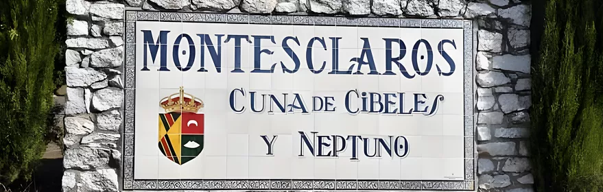 Panel cerámico de bienvenida sobre muro de piedra con cipreses al fondo