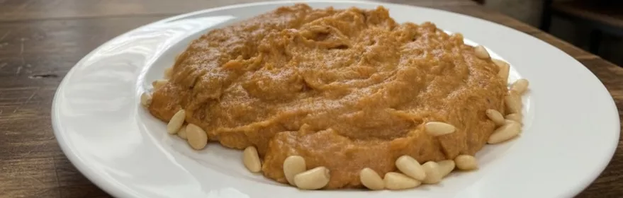 Morteruelo manchego cremoso con piñones en plato blanco