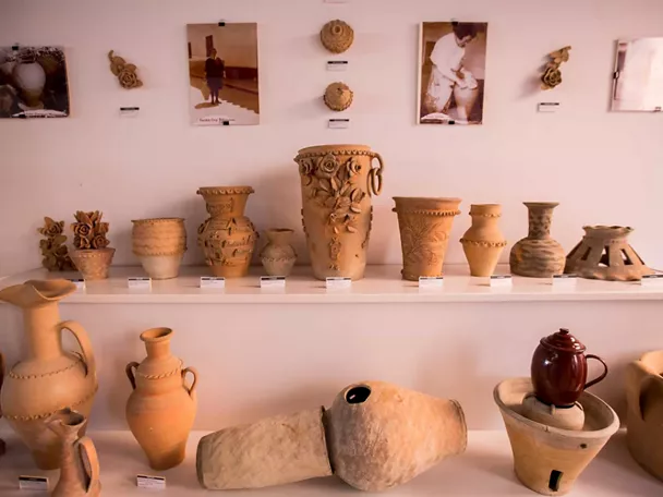 Vitrina con colección de cerámica artesanal de distintos tamaños y formas.