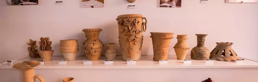 Vitrina con colección de cerámica artesanal de distintos tamaños y formas.