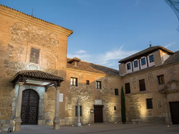 Patio de edificio histórico de piedra y ladrillo al atardecer.