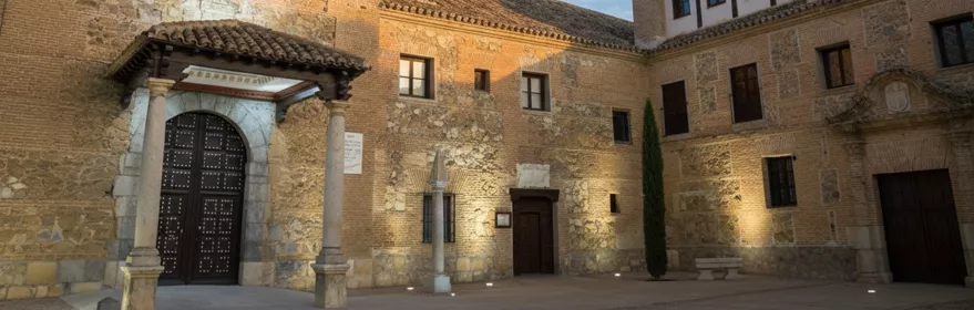 Patio de edificio histórico de piedra y ladrillo al atardecer.