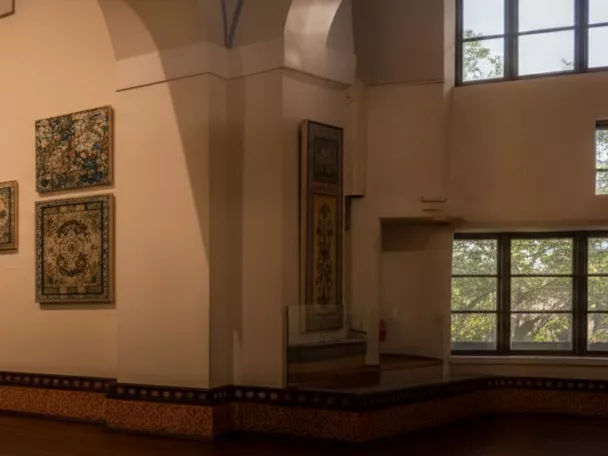 Gran sala iluminada con paneles de azulejos y ventanales, vista panorámica del museo.