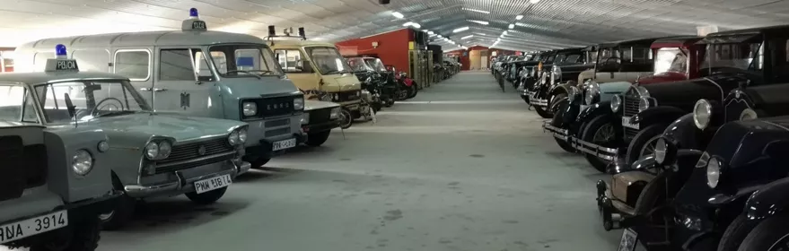 Pasillo central con vehículos antiguos a ambos lados.