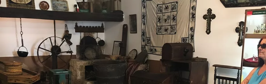 Sala museística con utensilios tradicionales, rueca y objetos religiosos.