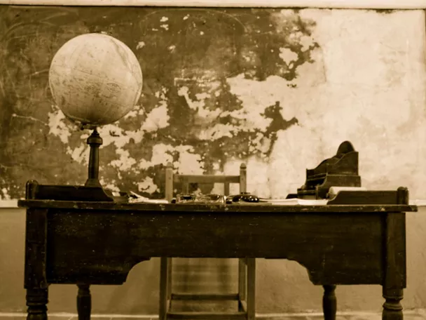 Antigua aula escolar con mesa del maestro.