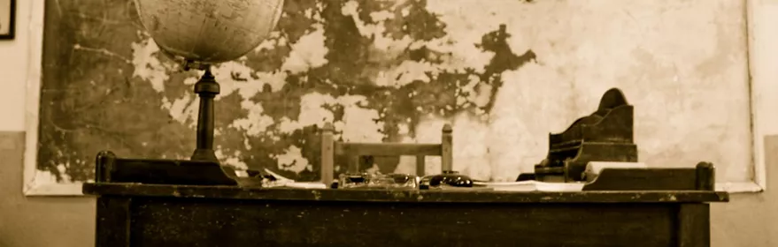 Antigua aula escolar con mesa del maestro.