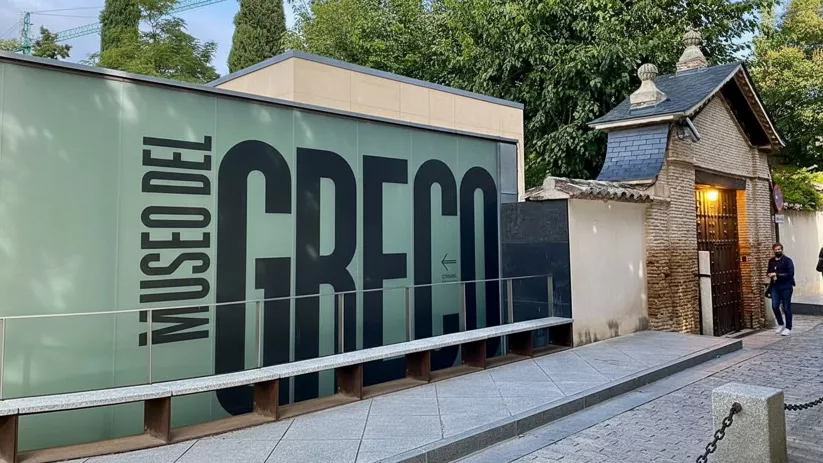 Fachada contemporánea de museo con gran rótulo y acceso lateral.