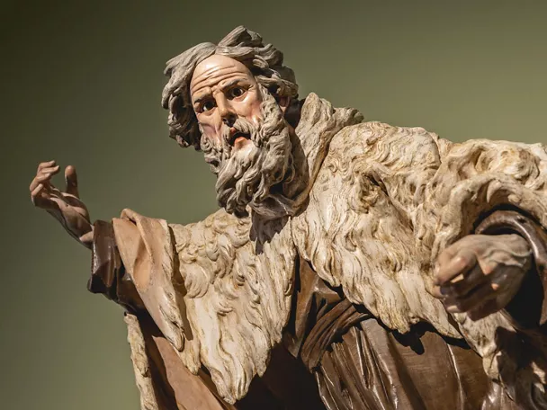 Escultura policromada de figura masculina con gesto expresivo.