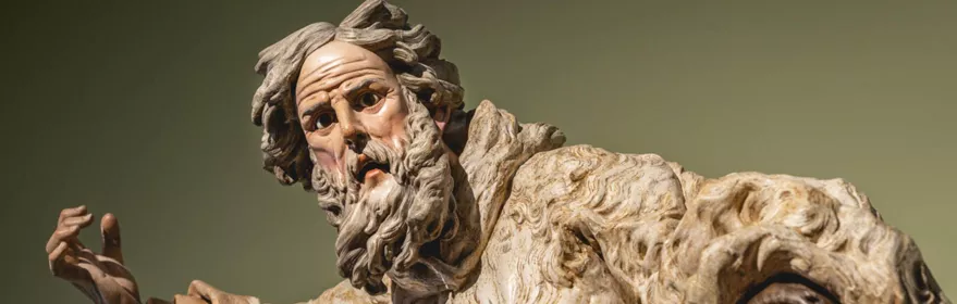 Escultura policromada de figura masculina con gesto expresivo.