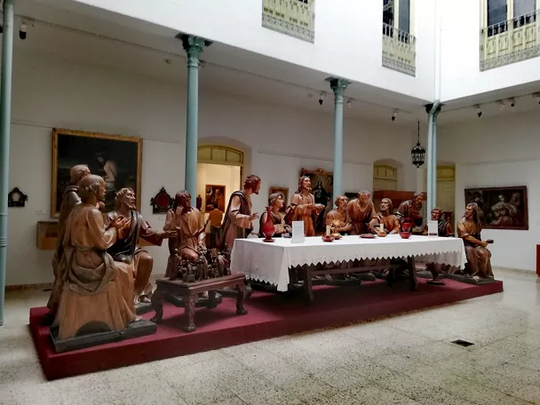 Conjunto escultórico de madera representando una escena religiosa alrededor de una mesa