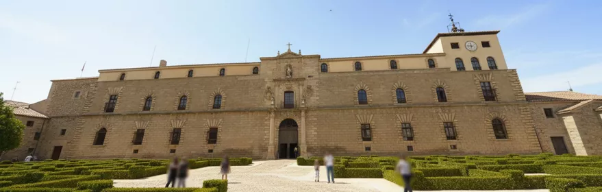 Fachada principal de piedra con jardín geométrico en primer plano.
