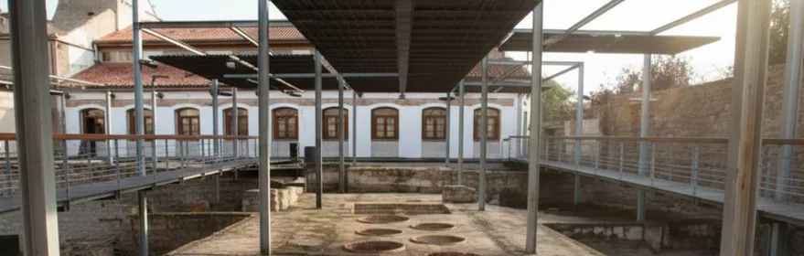 Patio industrial con pasarelas metálicas y varias piletas circulares en el suelo.