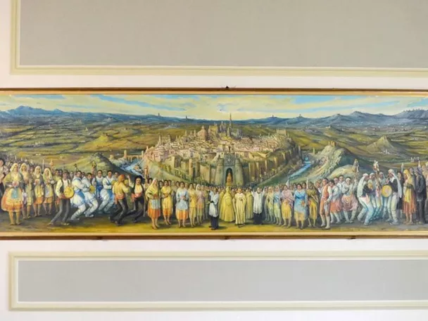 Gran mural con ciudad al fondo y personas en primer plano