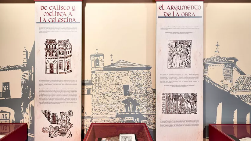 Paneles informativos con ilustraciones antiguas y vitrina con libro expuesto.