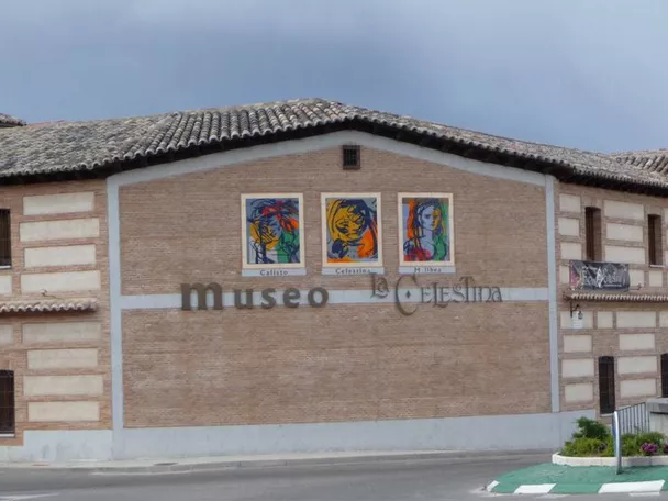 Fachada de edificio de ladrillo con carteles ilustrados y entrada principal.