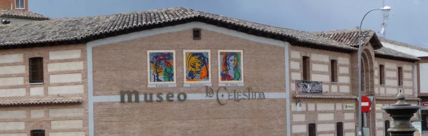 Fachada de edificio de ladrillo con carteles ilustrados y entrada principal.