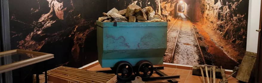 Vagoneta con rocas en sala expositiva.