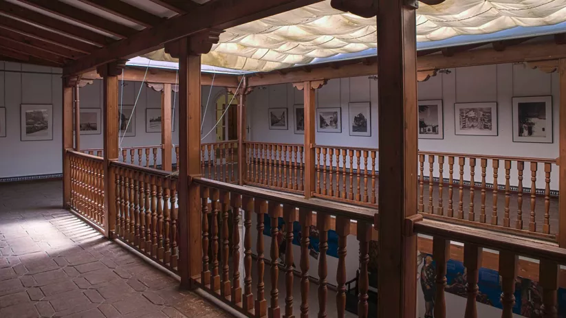Galería interior con balconada de madera y techo acristalado