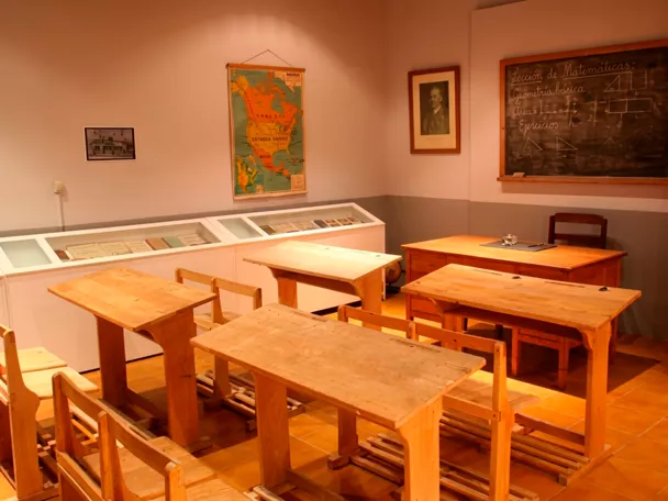 Aula escolar antigua con pupitres de madera