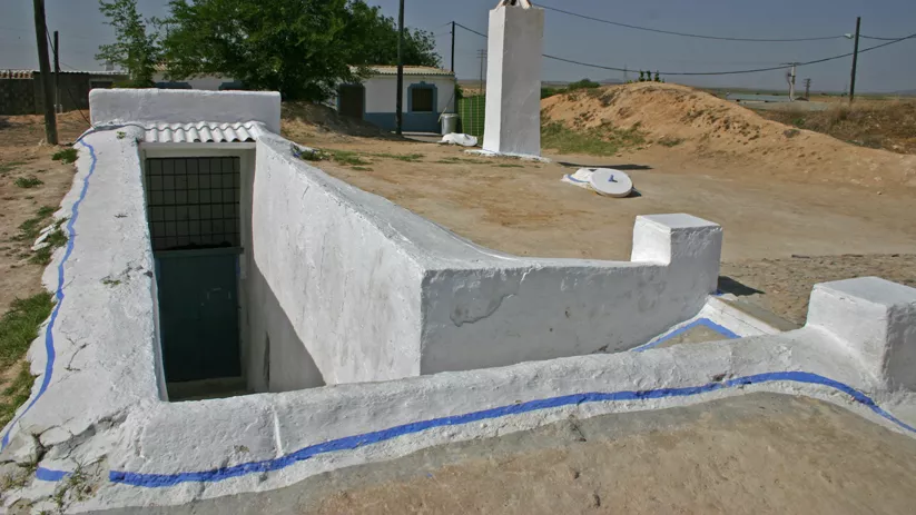 Entrada subterránea encalada en terreno seco