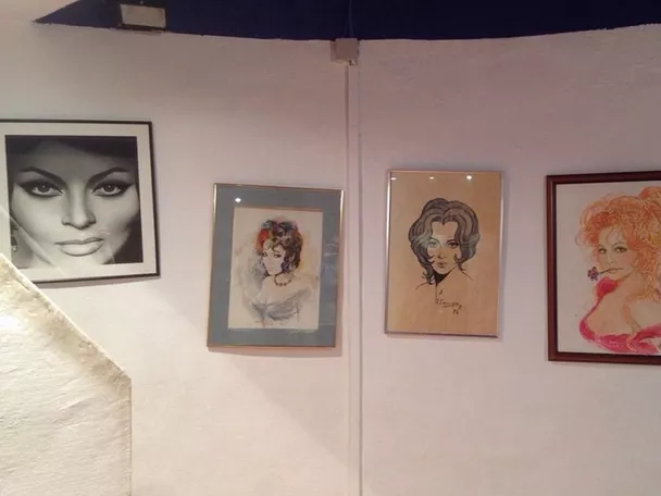 Galería con retratos femeninos enmarcados sobre pared blanca