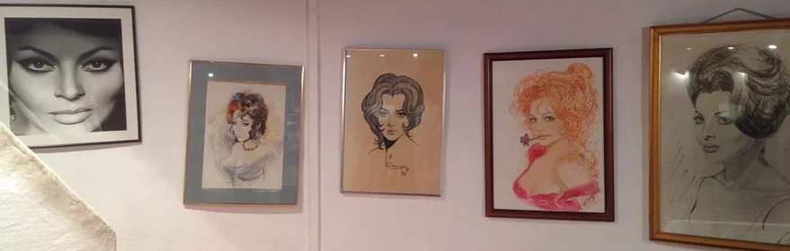 Galería con retratos femeninos enmarcados sobre pared blanca