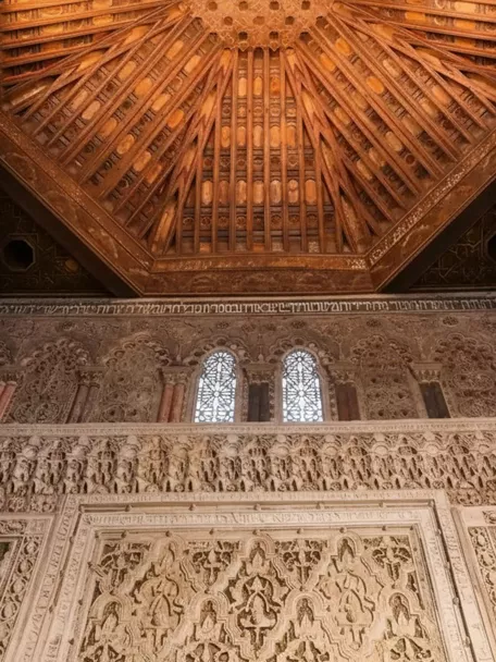 Detalle de techo de madera tallada y friso decorativo.