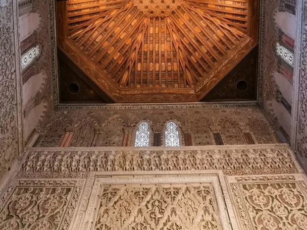 Detalle de techo de madera tallada y friso decorativo.