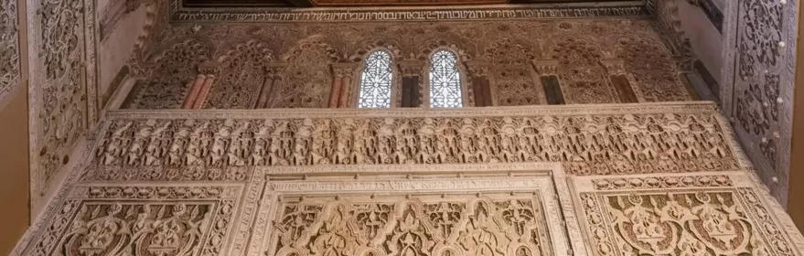 Detalle de techo de madera tallada y friso decorativo.