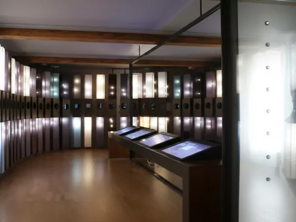 Sala expositiva con paneles iluminados y pantallas táctiles.