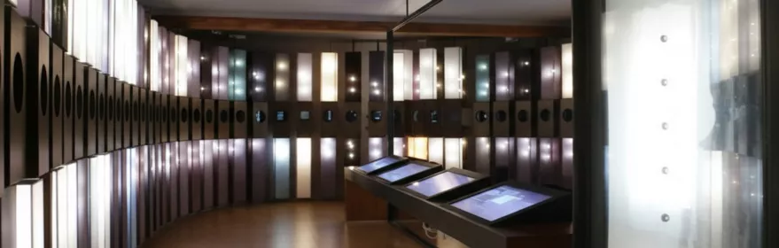 Sala expositiva con paneles iluminados y pantallas táctiles.