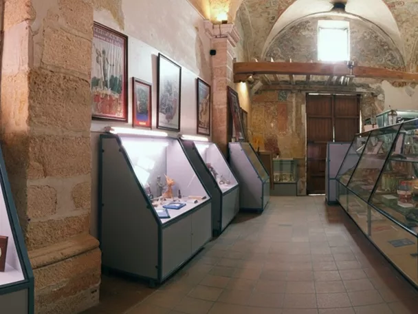Pasillo de museo con vitrinas y tambores expuestos en una larga vitrina lateral.