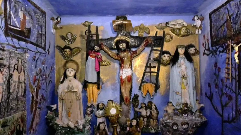 Pequeño altar azul con crucifijo, vírgenes y ángeles